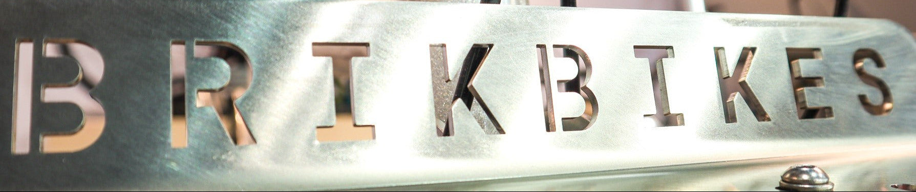 Metallic sign with 'BRIKBIKES' on a blurred bicycle background